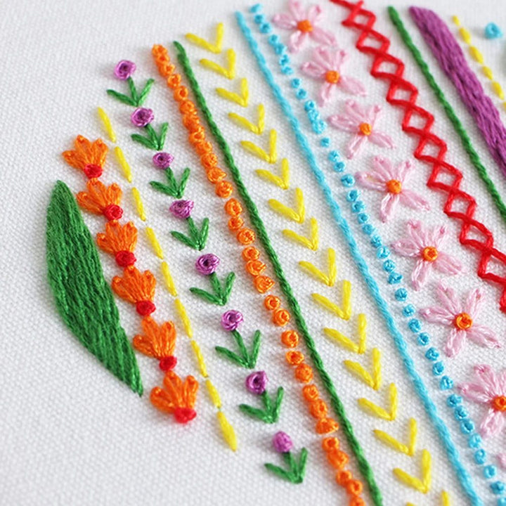 Heart-shaped embroidery pattern on woven fabric with colorful threads, part of Simple Embroidery Kits for Beginners.